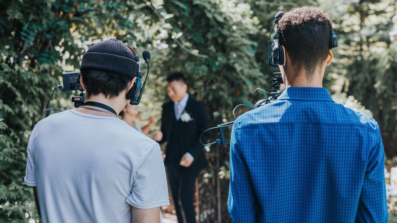 Two Skytona filmmakers filming a couple along a garden path.